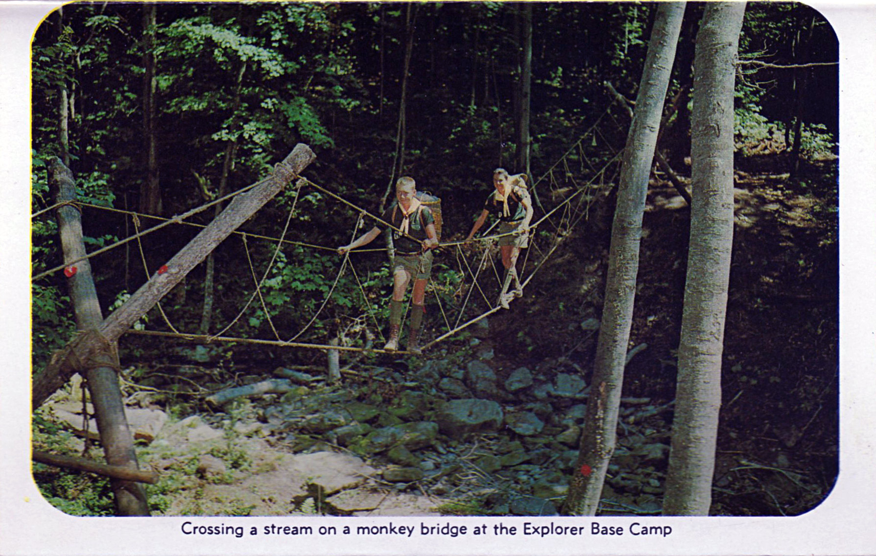 Crossing a stream on a monkey bridge at the Explorer Base Camp